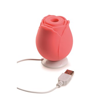 Gossip Come Into Bloom Rose Clitoral Stimulator - Showing Product Placed in Charging Station - Coral