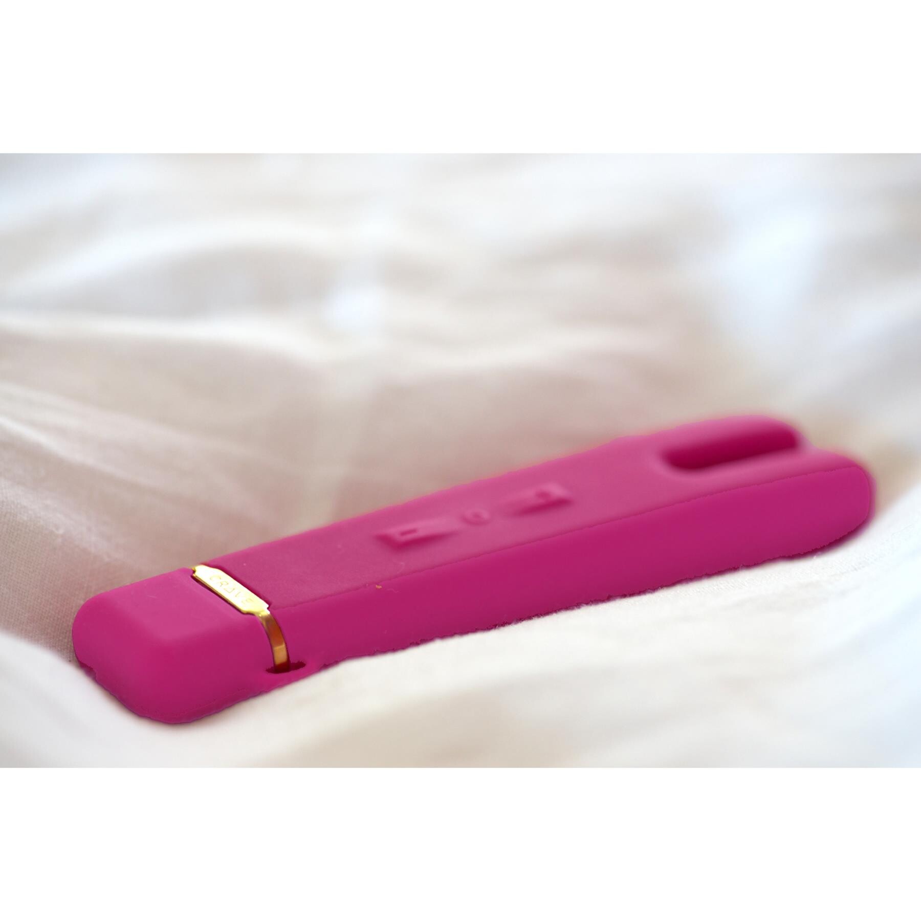 Crave Duet Flex Vibrator pink on bed