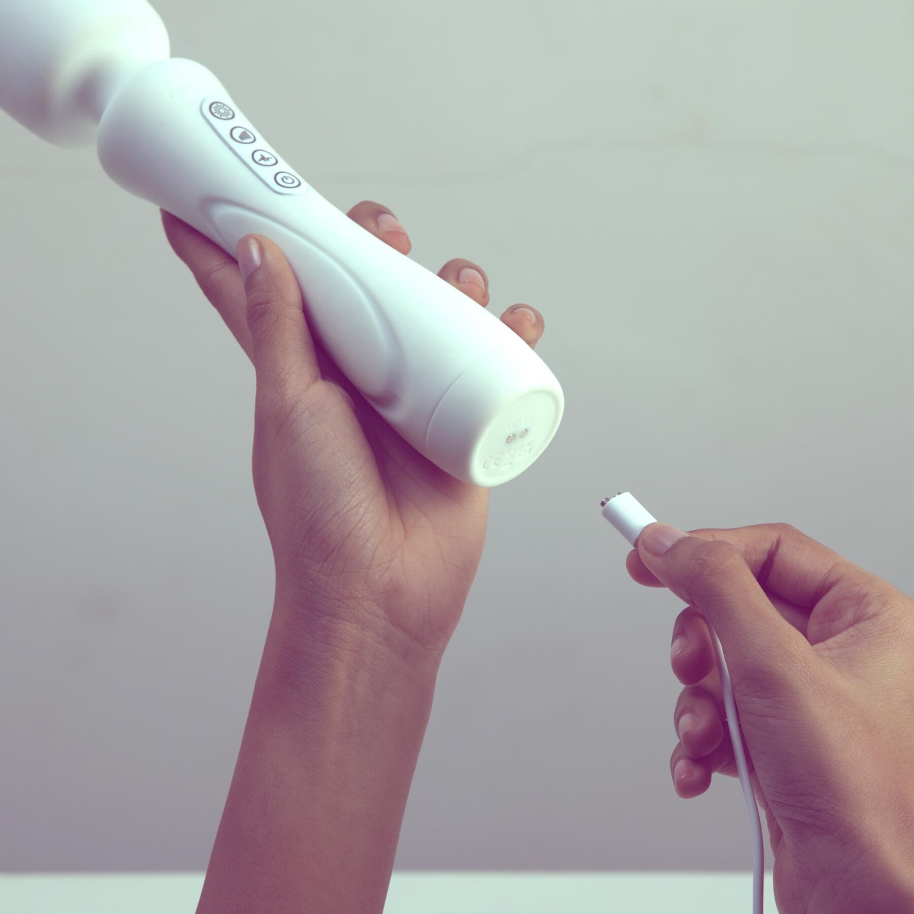 Illumination Wand Massager showing the charging cable being plugged into the bottom