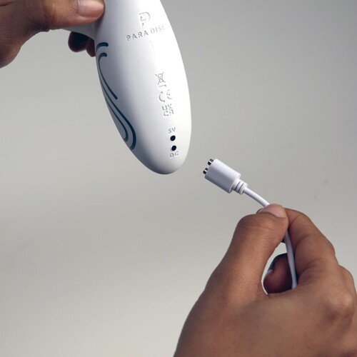Illumination Rabbit Vibrator showing the charging cable being plugged into the bottom